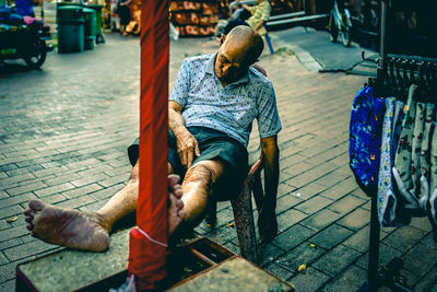 Man sleeping on chair in market