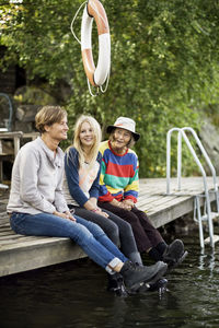 Three generation females sitting on pier