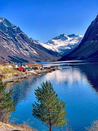 Scenic view of lake by snowcapped mountains against sky