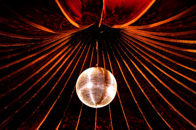 Low angle view of disco ball hanging from decorated ceiling