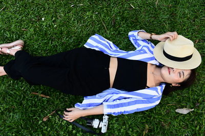 High angle view of woman lying on grassy field