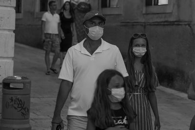 Portrait of happy girl standing against built structure