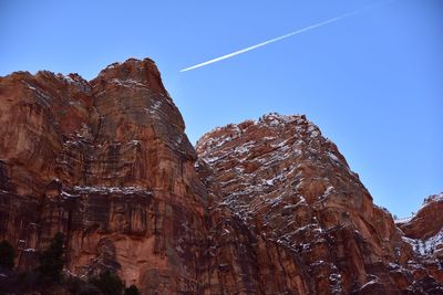 Low angle view of vapor trail against clear blue sky