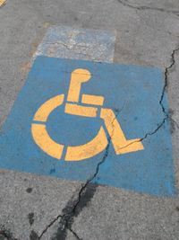 High angle view of road sign on cracked street