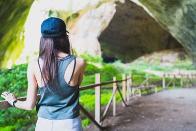 Rear view of woman standing against plants