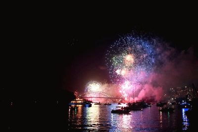 Firework display over river at night