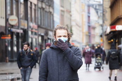 Portrait of man standing on street in city
