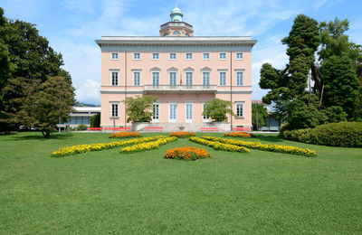 Lawn in front of building against sky