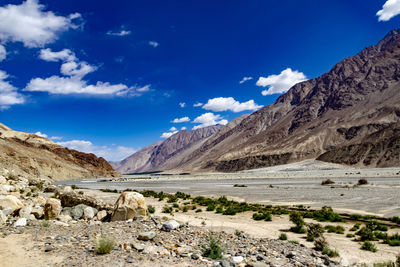 Scenic view of landscape and mountains against blue sky