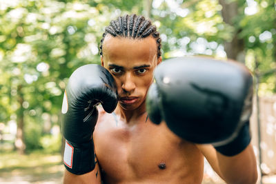 Portrait of shirtless man boxing on street