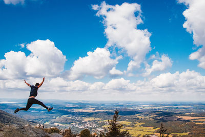Full length of man jumping against sky