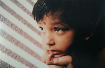 Close-up of boy looking away by wall