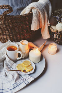 High angle view of tea by burning candles on table