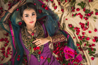 High angle portrait of bride lying on textile