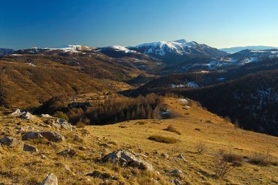 Scenic view of snowcapped mountains against clear blue sky