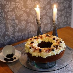 Close-up of dessert with lit candles on table