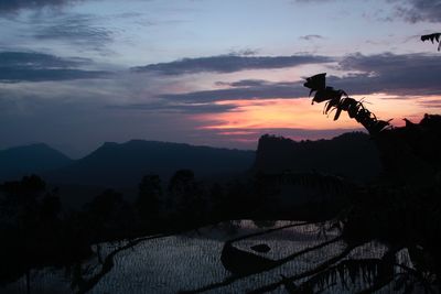 Scenic view of silhouette mountains against sky at sunset