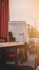 Vehicles on road against sky in city