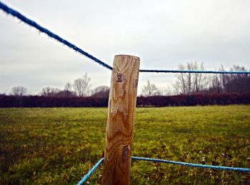 Wooden fence on field against sky