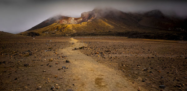 Scenic view of land and mountains against sky