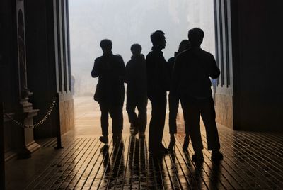 Rear view of silhouette people walking in corridor