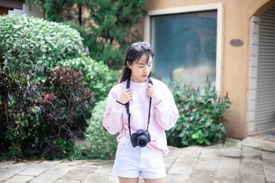 Full length of woman standing against plants