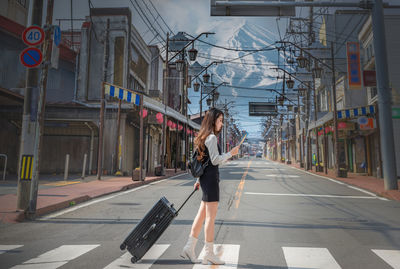 Side view of woman walking on street in city