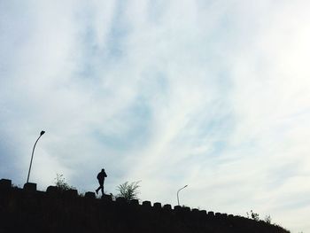 Low angle view of silhouette trees against sky