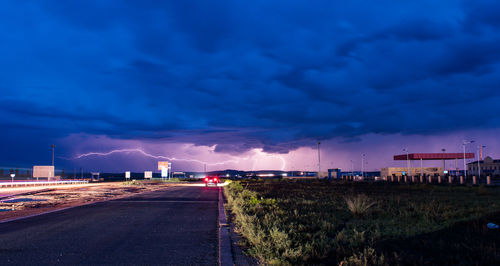 Road in city against blue sky at dusk
