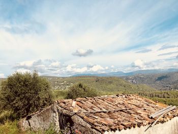 Stack of logs on landscape against sky