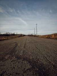 Road amidst field against sky