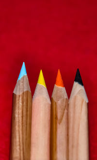 Close-up of colored pencils against red background