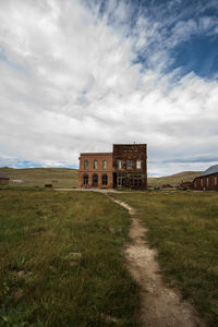 Old building on field against sky ghost town