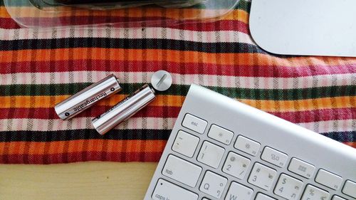 Directly above shot of batteries with computer keyboard on table