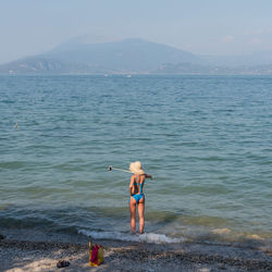 Full length of shirtless man on beach against sky