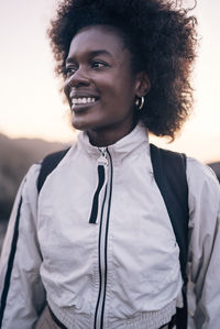 Happy female explorer looking away wearing white jacket