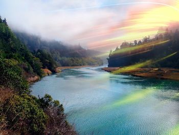 Scenic view of river against cloudy sky