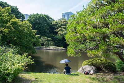 Rear view of woman standing by lake