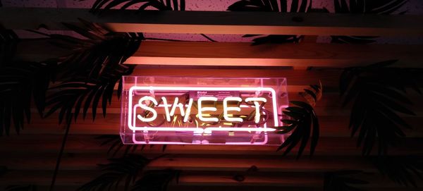 Low angle view of illuminated neon sign at night