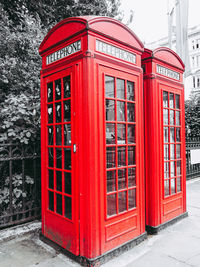 Red telephone booth on street in city