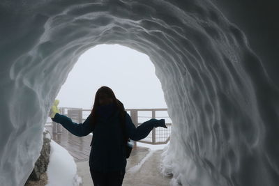 Rear view of woman standing at sea shore