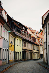 Street amidst buildings in town against sky