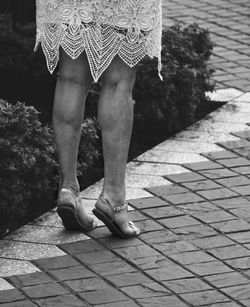 Low section of woman standing on footpath