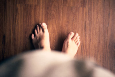 Low section of woman legs on wooden floor