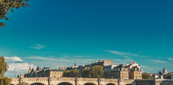 Buildings in city against blue sky