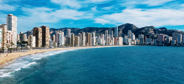 Panoramic view of sea and buildings against sky