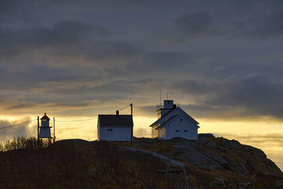 Building by sea against sky during sunset