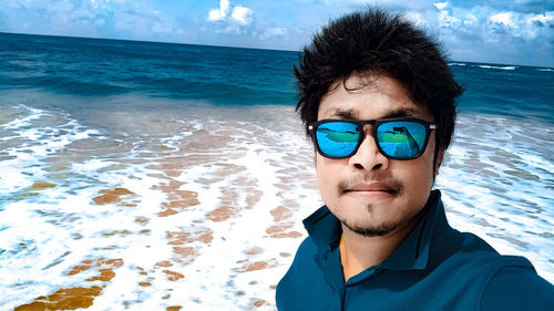 Portrait of man wearing sunglasses against sea