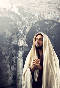 Portrait of man standing at temple against building