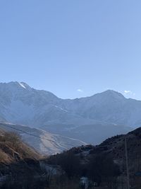 Scenic view of snowcapped mountains against clear blue sky